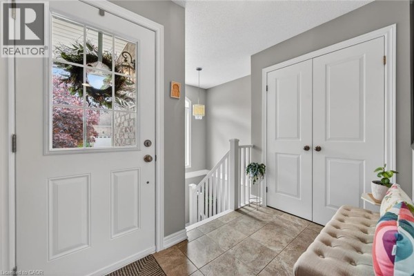 Bathroom with a white vanity, sink, toilet, and a shower with a patterned curtain. - 38 Gamble Lane, Port Dover