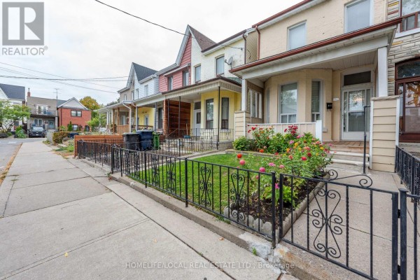 View of residential homes on Gordon Street, Toronto, from across the street, showing front yards and porches. - 38 Gordon Street, Toronto