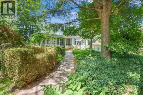 Stone walkway leading to a white house with a covered porch and gardens. - 38 Harold Street South, Ridgetown