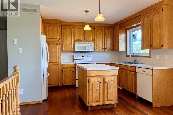 Kitchen with light oak cabinetry, white countertops, an island, and stainless steel appliances. - 38 Heritage Cove, Rosthern Rm No  403