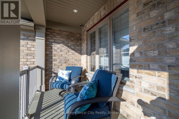 Close-up of a small covered porch with two blue cushioned chairs and side table. - 38 Juniper Street, Guelph/eramosa