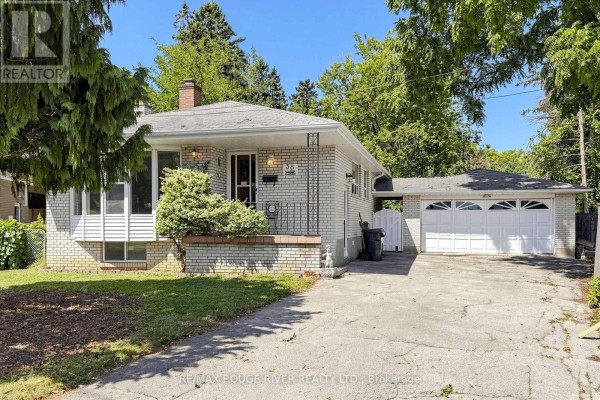 Front exterior of a brick bungalow with a pitched roof and a double garage. - 38 Lombardy Crescent, Toronto
