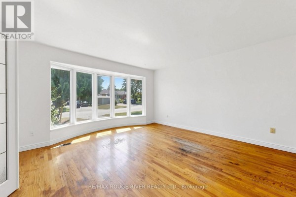 Living room with hardwood floors and a large bay window offering a street view. - 38 Lombardy Crescent, Toronto