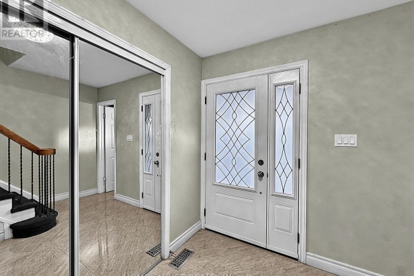 Primary bedroom with king bed, dresser, and a vanity with illuminated mirror. - 38 Robbinstone Drive, Toronto