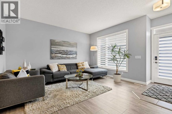 A wooden deck with potted plants, flowers, and a storage box in a backyard. - 38 Sage Bluff Gate Nw, Calgary