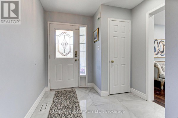 Interior view of a bright foyer with light grey walls, white doors, and marble tile flooring. - 38 Sundew Drive, Barrie