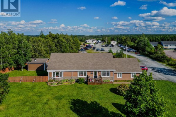 Exterior aerial view of a long, single-story residential building with a detached garage. - 380-380a Gander Bay Road, Gander