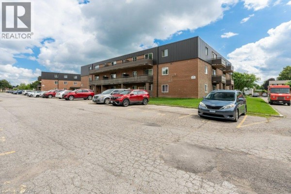 Parking lot with cars in front of apartment building in daytime. - 380 Admiral Drive Unit# 208, London