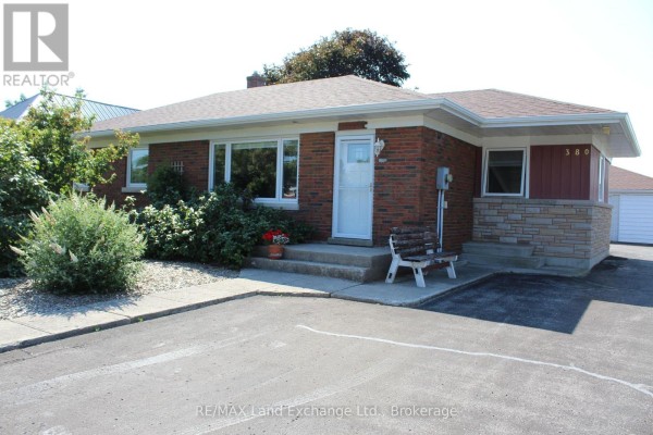 Brick bungalow with white door and window trim, stone accent, and asphalt driveway. - 380 Princes Street S, Kincardine