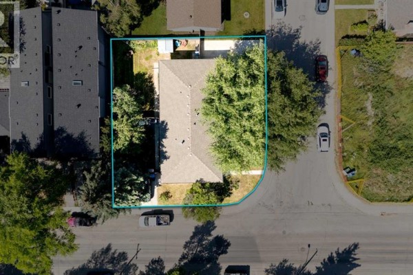 Aerial view of a single-family home with a light brown roof, surrounded by trees and located on a paved street. - 3803 4 Avenue Sw, Calgary
