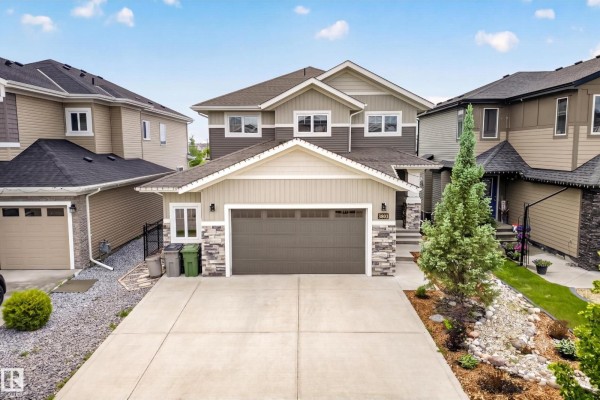 Backyard view of a two-story house with a deck, gazebo, and fenced lawn. - 3803 48 Av, Beaumont
