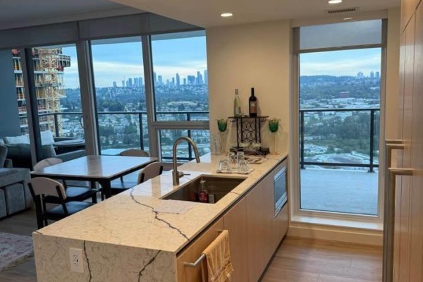 Kitchen island with granite countertop and dining area with city view. - 3805 2135 Springer Avenue, Burnaby