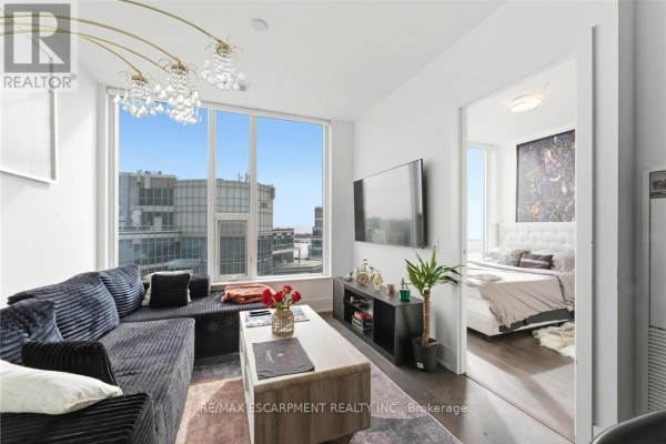 Living area with sectional sofa, decorative chandelier, and wall-mounted TV - 3807 - 10 York Street, Toronto