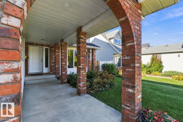 View from the covered porch showing the front door and brick columns supporting the overhang. - 3807 36 Av Nw, Edmonton