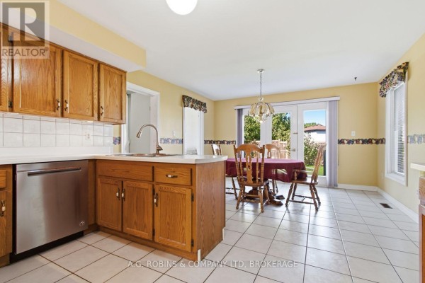 Interior foyer with a curved wooden staircase with blue carpet and a balcony above. - 381 Kerman Avenue, Grimsby