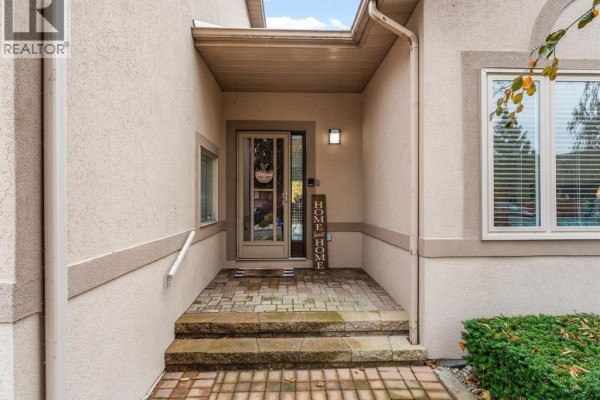Covered front entrance with stone steps, a glass door, and sidelight windows. - 381 Tuscany, Tecumseh