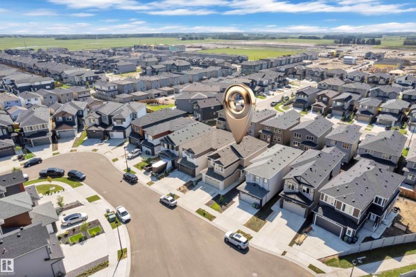 Aerial view of a suburban neighborhood with a cluster of similar-style houses under a blue sky. - 3811 42 Av, Beaumont