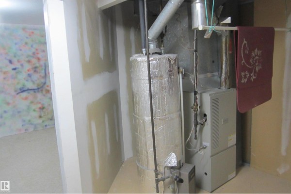 Furnace and water heater in a room with unfinished drywall walls and taped seams. - 3814 37 Av, Leduc