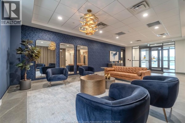 Lounge area in apartment building with patterned blue walls and seating. - 3817 Howard Avenue Unit# 109, Windsor