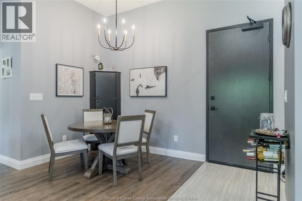 Dining area with round table, chairs, black cabinet, and door. - 3817 Howard Avenue Unit# 109, Windsor