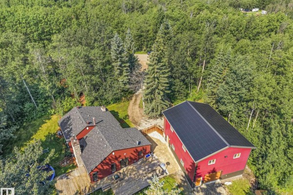 Aerial view of red house and large red detached garage in a wooded setting. - #382 51112 Rge Road 222, Rural Strathcona County