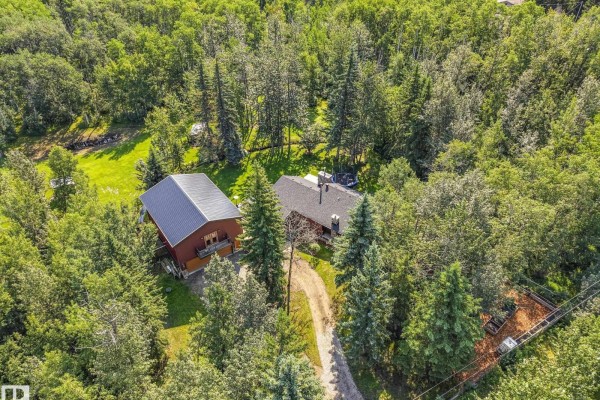 Aerial drone shot of a red house and outbuilding nestled amongst lush green trees. - #382 51112 Rge Road 222, Rural Strathcona County