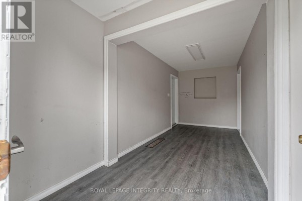 Interior hallway with light grey walls, white trim, and dark grey wood-look vinyl flooring. - 3823 Drouin Road, Clarence Rockland