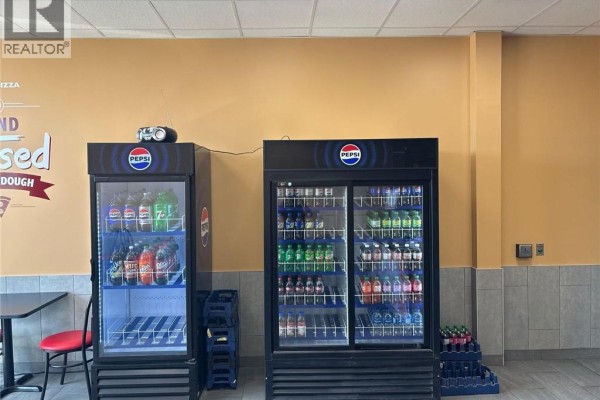 Two tall Pepsi brand beverage refrigerators filled with assorted drinks, next to a wall. - 383 Arthur Street S Unit# 5, Elmira