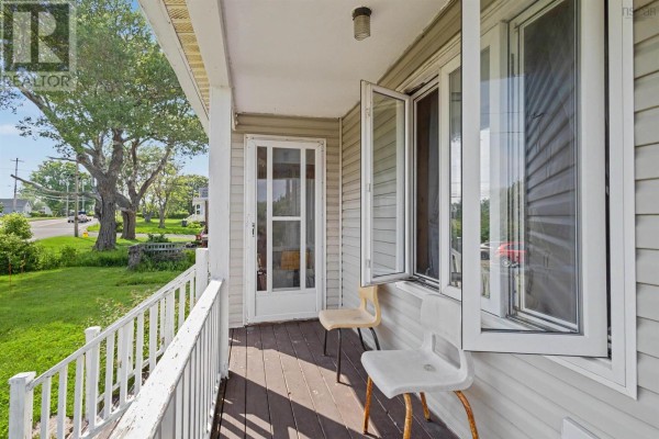 Close-up of the front porch with two chairs, a screen door, and open windows. - 383 Kings Road, Dominion