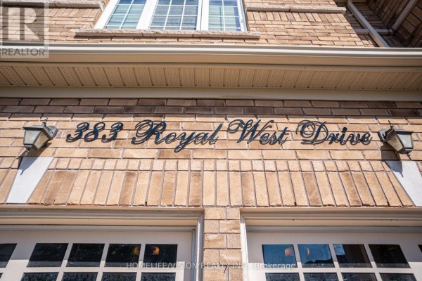 Black house numbers "383 Royal West Drive" above two garage doors on a brick facade. - 383 Royal West Drive, Brampton
