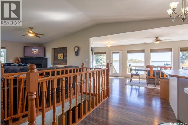 View of living room and dining area with large windows showing a lake view. - 3830 First Point Beach Drive, Wakaw Lake