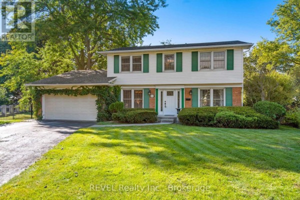 Ariel view of a two-story white house with green shutters and a landscaped front yard. - 3839 Potter Heights, Niagara Falls