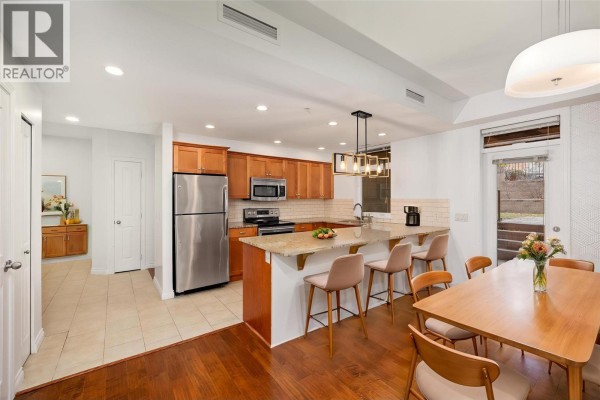 Open kitchen with granite countertops, stainless steel appliances, and pendant lighting. - 3843 Brown Road Unit# 2101, West Kelowna