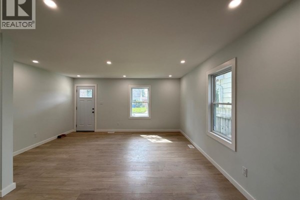 Living room with white door, windows, and light grey walls. - 3847 Matchett Road, Windsor