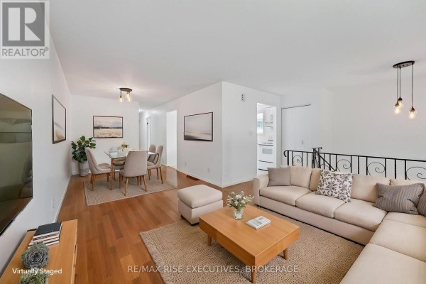 Staged living and dining area with a sectional sofa, coffee table, dining set, and hardwood floors throughout the open space. - 385 Melanie Avenue, Kingston