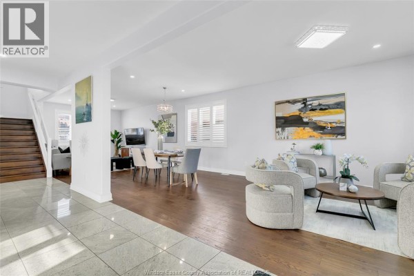 Living area with seating, hardwood floors, and dining space, featuring modern decor. - 3852 Concord Court, Windsor