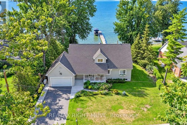 Aerial view of a residential home with a garage, driveway, and lake access. - 3852 Muley Point Road, Ramara