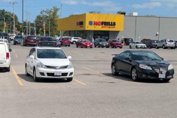Parking lot view with cars, and a "No Frills" grocery store in the background. - 3857 Wyandotte Street East, Windsor