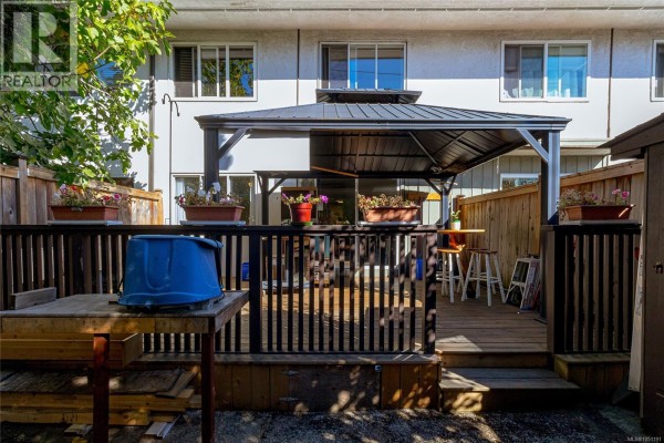 Wooden backyard deck with covered gazebo, railing, and seating. - 386 Burnside Rd W, Saanich