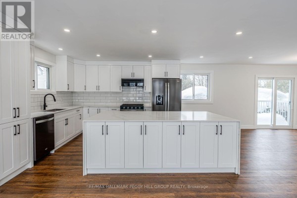 Dining area with a wooden table, four chairs, and sliding doors leading to the deck. - 386 Peter Street N, Orillia