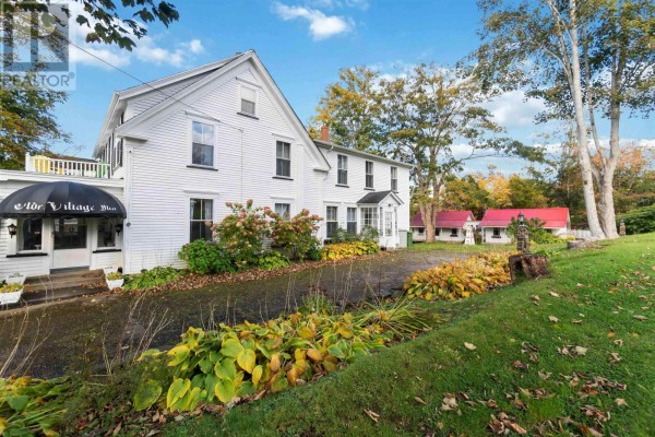 Front view of the white Inn with a paved driveway and manicured landscaping. - 387 Church Hill Road, Sandy Cove