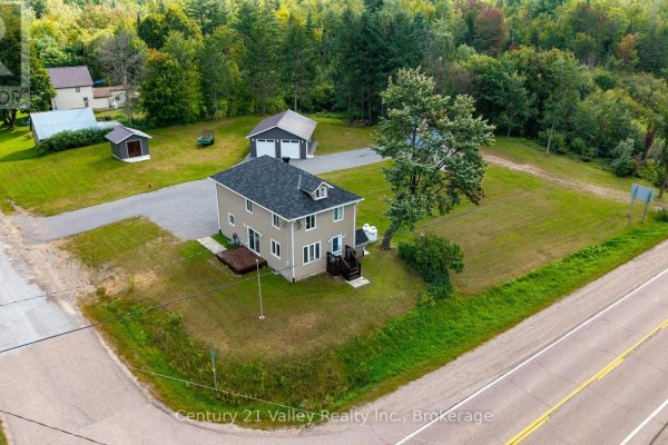 Two-car garage with gray doors and a long gravel driveway leading to it. - 387 Sell Road, North Algona Wilberforce