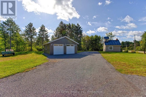 Aerial view of the property showing the house, garage, small outbuildings, and surrounding rural landscape. - 387 Sell Road, North Algona Wilberforce