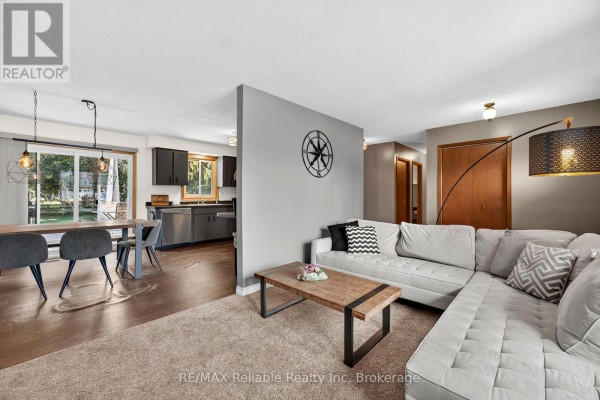 Open concept living room and kitchen with modern dark cabinets and white sectional. - 38823 Vienna Street, Bluewater