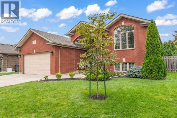 Side view of the red brick house with a young tree in the front yard. - 389 Donlon, Lasalle