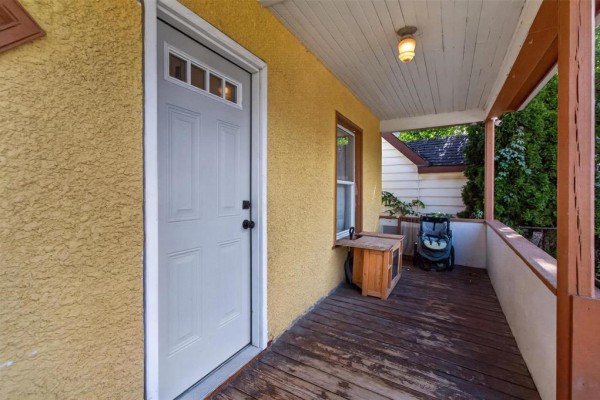 View of the front door and porch area with a wooden deck. - 389 Harbison Avenue W, Winnipeg