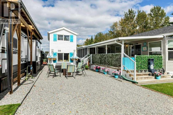 Gravel pathway between an RV, a white tiny house, and a beige mobile home with a covered porch. - 39, 12036 Township Road 422, Rural Ponoka County