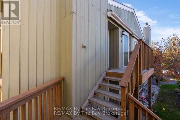 View of wooden stairs leading up to an apartment balcony with sliding glass doors. - 39 - 19 Dawson Drive, Collingwood