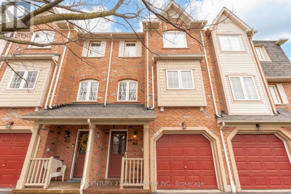 Close-up of townhouse unit 39's red front door with a glass pane and black hardware. - 39 - 7190 Atwood Lane, Mississauga