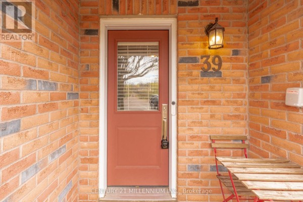 Exterior detail of townhouse unit 39's entrance and adjacent garage, surrounded by brick. - 39 - 7190 Atwood Lane, Mississauga